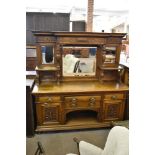 A large Victorian oak mirror back sideboard, the raised mirror back of breakfront form with