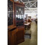 An astragal glazed mahogany double corner cupboard, having an urn topped surmount over plain