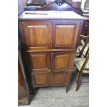 An Edwardian Mahogany three stage cupboard, each stage with panelled doors between fluted ends.