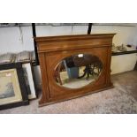 And Edwardian inlaid mahogany overmantel mirror, having dentil inlaid surmount and bevelled oval