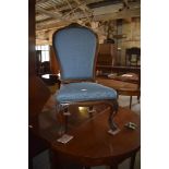 A Victorian rosewood framed nursing chair, the spoon shaped back with padded upholstery and carved