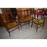 An Edwardian stained wood three piece salon suite, comprising a two seater settee and two armchairs,