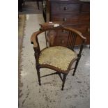 An Edwardian inlaid mahogany corner armchair with padded seat and turned supports
