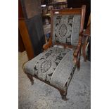 A Victorian oak framed easychair, with incised rails and patterned foliate upholstery seat height.