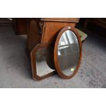 Two early 20th century mahogany wall mirrors, one of canted rectangular form, the other oval.