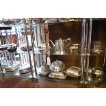 Two shelves of silver plated wares, to include mainly entree dishes.
