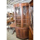 A reproduction bow fronted mahogany corner cupboard, with glazed upper doors. 206 CM.