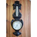 A Victorian carved and stained oak barometer, having thermometer scale over circular barometer dial,