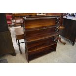 An early 20th century simulated Rosewood waterfall bookcase, with fret cut and stepped ends.