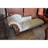 A late Victorian mahogany show frame chaise longue, having a deep buttoned scrolled arm and shaped