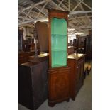 A slender reproduction mahogany double corner cupboard with dentil molded over green painted