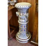 A large Victorian design pottery plant pedestal, decorated with rams and lion head ornaments and