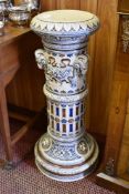 A large Victorian design pottery plant pedestal, decorated with rams and lion head ornaments and