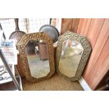 Two early 20th century embossed brass mounted bevelled mirrors, of canted rectangular form.