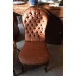 A Victorian carved mahogany nursing chair, the arched back with well carved foliate crest over the