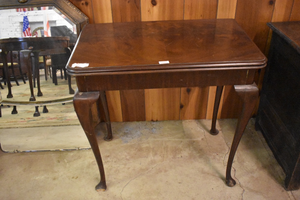 A 20th century figured mahogany card table, with folding top and swivel action. Small depletion to