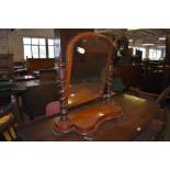 A Victorian mahogany swing dressing mirror with barley twist turned uprights and shaped platform.