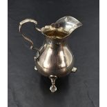 A George V silver cream jug, of baluster form with scrolled handle, generous spout and three trefoil