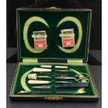 An early 20th century cased manicure set, with vibrant green fitted interior, one tool replaced