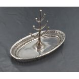 A George V silver ring stand, having a six branch central tree seated on an oval base with pierced