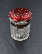 An Edwardian enamelled silver topped dressing table jar, the cushion shaped top enamelled in rich