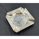 A George VI silver ashtray, of square outline with central circular well enclosed by an engine-