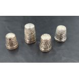 A group of four silver and white metal thimbles, two with English hallmarks, two marked Sterling,