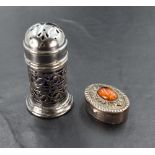 An imported silver pill box, of oval form with central oval amber cabochon, London import marks