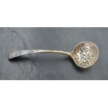 An 18th century silver sifting spoon, the circular bowl with bead moulded rim enclosing the