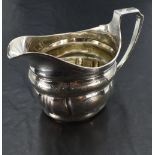 A George III silver cream jug, of helmet form with reeded rim and moulded body with bands of