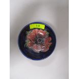 A vintage Moorcroft pin dish having tube lined anemone pattern to cobalt blue ground.