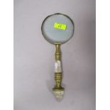 A brass framed antique magnifying glass having mother of pear inlay to handle.