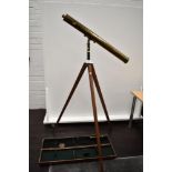 An antique floor standing brass bodied refractor telescope with three inch brass tube