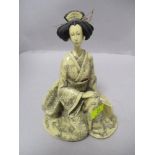 An oriental composite figurine of a lady in traditional dress.