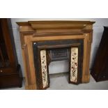 A Victorian style cast , tiled and stripped wood fire surround
