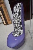 A designer chair modelled as a stiletto in purple vinyl and faux zebra skin