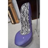 A designer chair modelled as a stiletto in purple vinyl and faux zebra skin