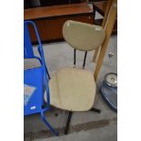 A vintage vinyl office chair on metal swivel frame
