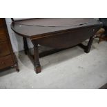 A reproduction oak banquetting style drop leaf table on chunky frame, large proportions