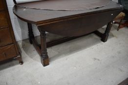 A reproduction oak banquetting style drop leaf table on chunky frame, large proportions