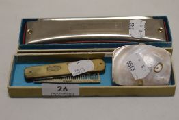 A selection of curios including mother of pearl coin purse, Masterwork harmonica and a bone handle