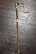 An early 20th century riding crop having silver tone metal cuff with embossed foxes head.