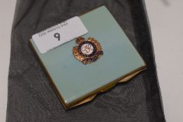 A 20th century ladies makeup compact with enamel case bearing a Royal Engineers badge