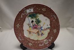 A late 19th century Chinese porcelain plate decorated with foliate border and panel of young boy