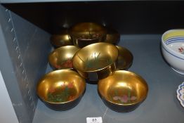 A set of eight Japanese wooden bowls with lacquer and gilt each having individual hand painted