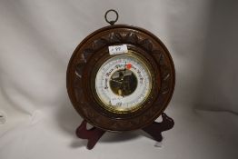 A late 19th century barometer with carved mahogany button case and enamel dial