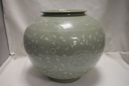 A 20th century Vietnamese celadon glazed pot of large size decorated with stalks and cranes in