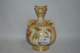 A Royal Worcester blush ivory twin handle vase with Greek style fluted neck and gilt borders with