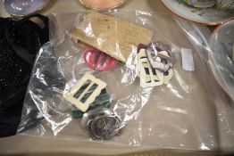 A collection of art deco buckles, predominantly early plastic, and an unused card of MOP buttons.