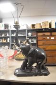 An Art Deco era table top lamp in the form of an elephant in carved wood